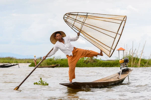 Inle Lake, Myanmar - 30 Ağustos 2016: Tanımlanamayan Birmanyalı balıkçı, özel el yapımı ağı olan bir teknede dengeyapıyor. Bu Myanmar balıkçılık geleneksel yoludur