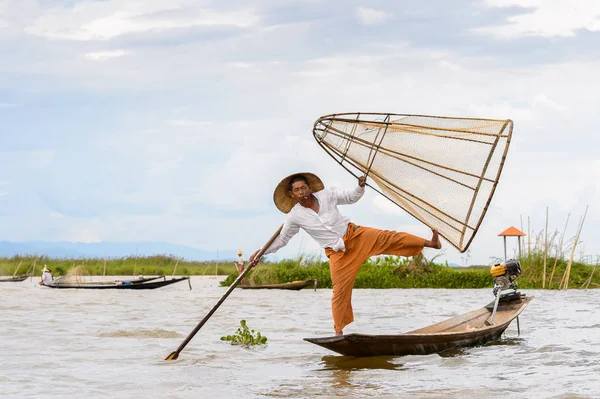 Inle Lake, Myanmar - 30 Ağustos 2016: Tanımlanamayan Birmanyalı balıkçı, özel el yapımı ağı olan bir teknede dengeyapıyor. Bu Myanmar balıkçılık geleneksel yoludur