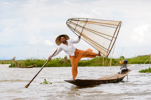 Inle Lake, Myanmar - 30 Ağustos 2016: Tanımlanamayan Birmanyalı balıkçı, özel el yapımı ağı olan bir teknede dengeyapıyor. Bu Myanmar balıkçılık geleneksel yoludur