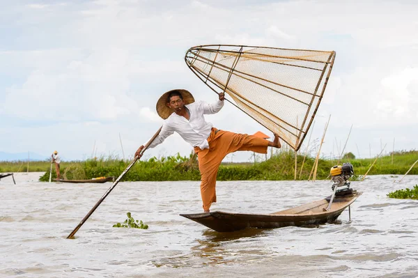 Inle Lake, Myanmar - 30 Ağustos 2016: Tanımlanamayan Birmanyalı balıkçı, özel el yapımı ağı olan bir teknede dengeyapıyor. Bu Myanmar balıkçılık geleneksel yoludur