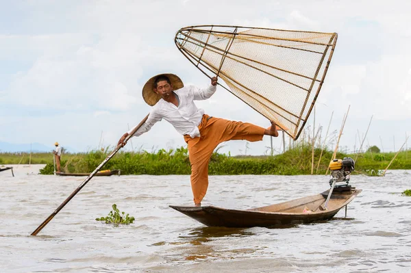 Inle Lake, Myanmar - 30 Ağustos 2016: Tanımlanamayan Birmanyalı balıkçı, özel el yapımı ağı olan bir teknede dengeyapıyor. Bu Myanmar balıkçılık geleneksel yoludur