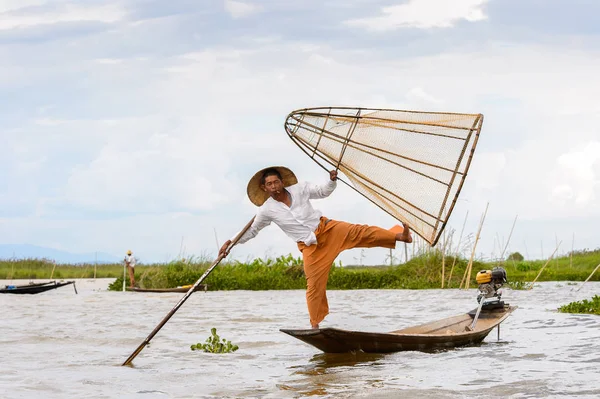 Inle Lake, Myanmar - 30 Ağustos 2016: Tanımlanamayan Birmanyalı balıkçı, özel el yapımı ağı olan bir teknede dengeyapıyor. Bu Myanmar balıkçılık geleneksel yoludur