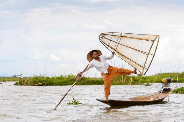 Inle Lake, Myanmar - 30 Ağustos 2016: Tanımlanamayan Birmanyalı balıkçı, özel el yapımı ağı olan bir teknede dengeyapıyor. Bu Myanmar balıkçılık geleneksel yoludur