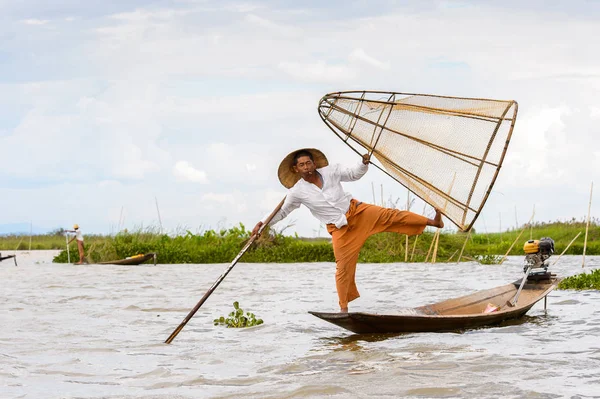 Inle Lake, Myanmar - 30 Ağustos 2016: Tanımlanamayan Birmanyalı balıkçı, özel el yapımı ağı olan bir teknede dengeyapıyor. Bu Myanmar balıkçılık geleneksel yoludur