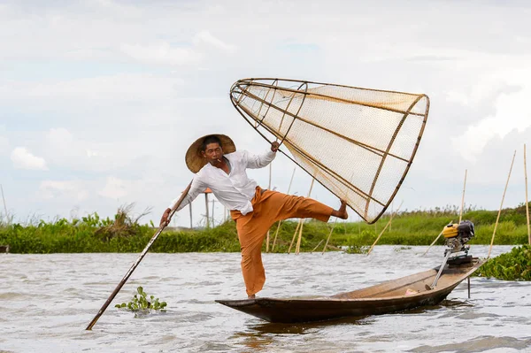 Inle Lake, Myanmar - 30 Ağustos 2016: Tanımlanamayan Birmanyalı balıkçı, özel el yapımı ağı olan bir teknede dengeyapıyor. Bu Myanmar balıkçılık geleneksel yoludur