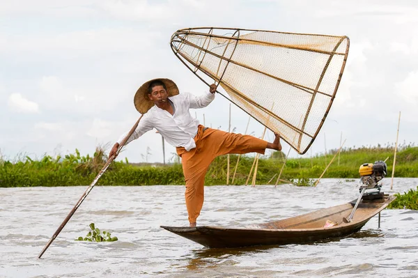Inle Lake, Myanmar - 30 Ağustos 2016: Tanımlanamayan Birmanyalı balıkçı, özel el yapımı ağı olan bir teknede dengeyapıyor. Bu Myanmar balıkçılık geleneksel yoludur