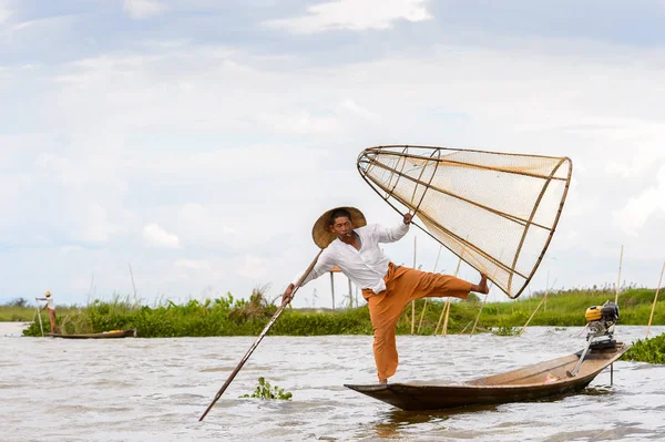 Inle Lake, Myanmar - 30 Ağustos 2016: Tanımlanamayan Birmanyalı balıkçı, özel el yapımı ağı olan bir teknede dengeyapıyor. Bu Myanmar balıkçılık geleneksel yoludur