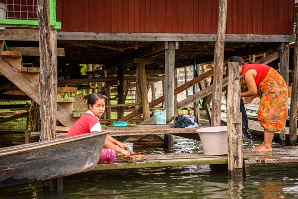 Inle Lake, Myanmar - 30 Ağustos 2016: Kimliği belirsiz Birmanyalı kadın, Shan Eyaleti'nin Taunggyi İlçesi'nin Nyaungshwe İlçesi'nde bulunan bir tatlı su gölü olan Inle Sap'ın üzerinde çamaşır yıkıyor