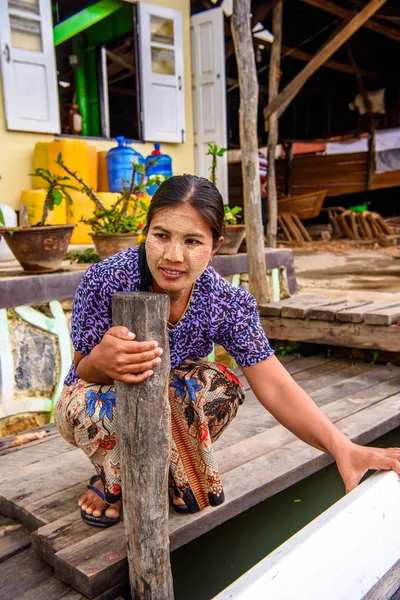 Inle Lake, Myanmar - 30 Ağustos 2016: Inle gölünün iskelesinde boyalı yüzü olan kimliği belirsiz Birmanyalı kadın. Myanma halkının yüzde 68'i Bamar etnik grubuna mensandı