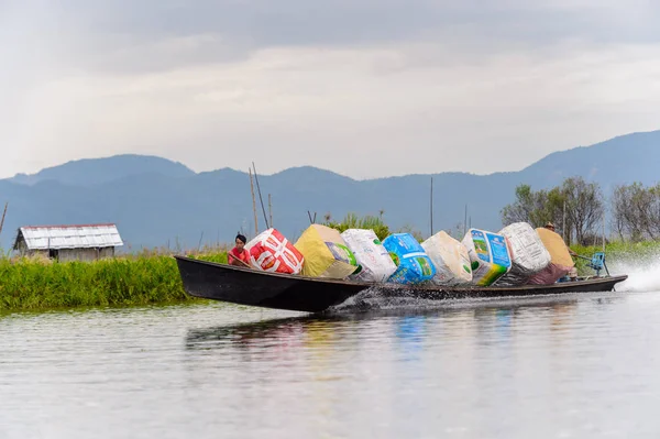 Inle Lake, Myanmar - 30 Ağustos 2016: Shan Eyaleti'nin Taunggyi İlçesi Nyaungshwe İlçesi'nde bulunan bir tatlı su gölü olan Inle Sap'ın üzerinde çantalı bambu teknede tanımlanamayan Birmanyalı adam