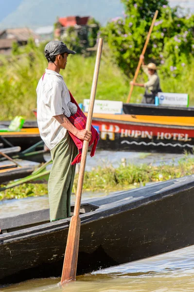 Inle Lake, Myanmar - 30 Ağustos 2016: Inle Gölü üzerinde ahşap bir teknede tanımlanamayan Birmanyalı adam. Myanma halkının yüzde 68'i Bamar etnik grubuna mensandı