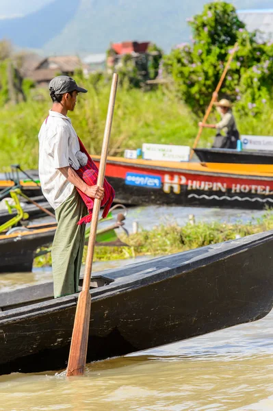 Inle Lake, Myanmar - 30 Ağustos 2016: Inle Gölü üzerinde ahşap bir teknede tanımlanamayan Birmanyalı adam. Myanma halkının yüzde 68'i Bamar etnik grubuna mensandı