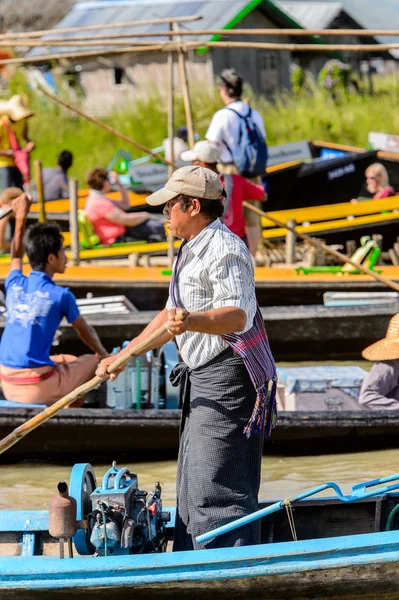 Inle Lake, Myanmar - 30 Ağustos 2016: Inle Gölü üzerinde ahşap bir teknede tanımlanamayan Birmanyalı adam. Myanma halkının yüzde 68'i Bamar etnik grubuna mensandı