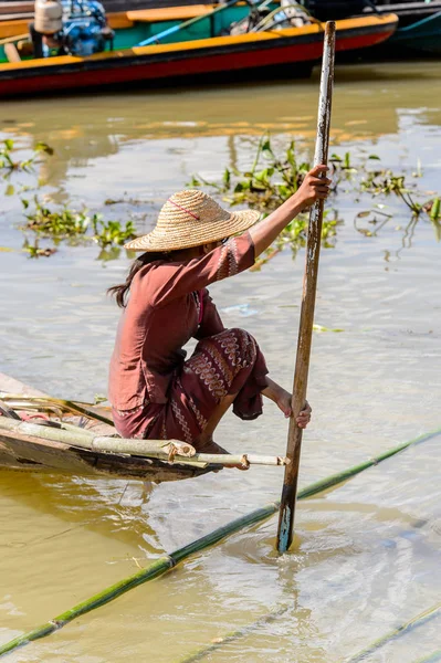 Inle Lake, Myanmar - 30 Ağustos 2016: Tanımlanamayan Birmanyalı kadın Inle Gölü üzerinde ahşap bir tekne sıralıyor. Myanma halkının yüzde 68'i Bamar etnik grubuna mensandı