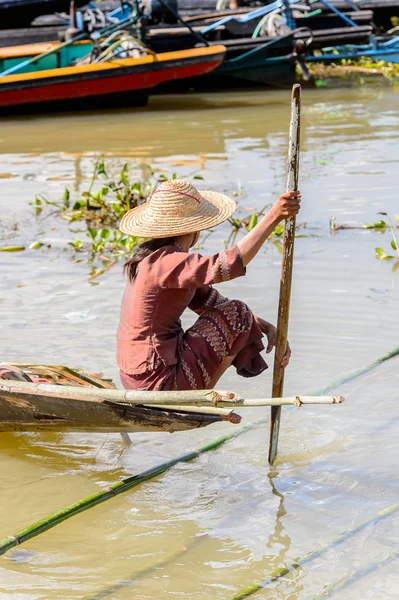 Inle Lake, Myanmar - 30 Ağustos 2016: Tanımlanamayan Birmanyalı kadın Inle Gölü üzerinde ahşap bir tekne sıralıyor. Myanma halkının yüzde 68'i Bamar etnik grubuna mensandı