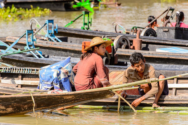 INLE LAKE, MYANMAR - AUG 30, 2016: Unidentified Burmese woman in bamboo boat over the Inle Sap,a freshwater lake located in the Nyaungshwe Township of Taunggyi District of Shan State, Myanmar