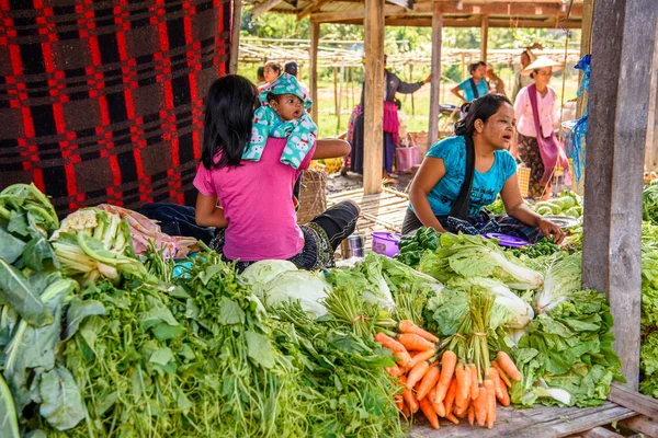 Inle Lake, Myanmar - 30 Ağustos 2016: Bir bebek ile tanımlanamayan Birmanya kadın pazar yerinde çalışır, Inle Sap, Shan State Taunggyi İlçesi Nyaungshwe İlçesi'nde bir tatlı su gölü, Myanmar