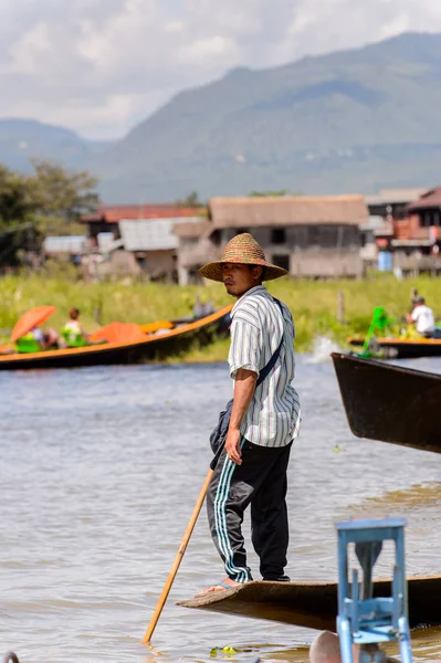 Inle Lake, Myanmar - 30 Ağustos 2016: Ahşap bir teknede tanımlanamayan Birmanyalı adam. Myanma halkının yüzde 68'i Bamar etnik grubuna mensandı