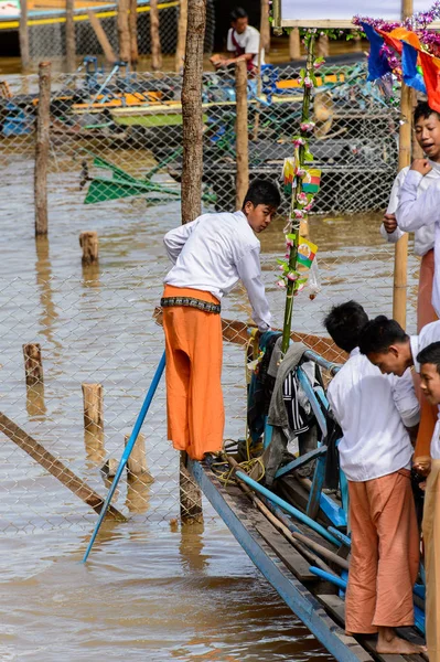 Inle Lake, Myanmar - 30 Ağustos 2016: Inle Gölü'nün iskelesinde ahşap bir tekne ile tanımlanamayan Birmanya çocuk. Myanma halkının yüzde 68'i Bamar etnik grubuna mensandı