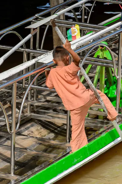 Inle Lake, Myanmar - 30 Ağustos 2016: Ahşap bir teknede tanımlanamayan Birmanyalı küçük çocuk. Myanma halkının yüzde 68'i Bamar etnik grubuna mensandı