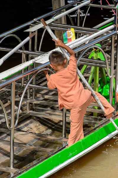 Inle Lake, Myanmar - 30 Ağustos 2016: Ahşap bir teknede tanımlanamayan Birmanyalı küçük çocuk. Myanma halkının yüzde 68'i Bamar etnik grubuna mensandı