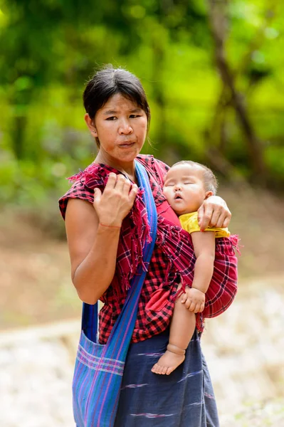 Inle Lake, Myanmar - 30 Ağustos 2016: Kimliği belirsiz Birmanyalı kadın küçük bebeğini taşıyor. Myanma halkının yüzde 68'i Bamar etnik grubuna mensandı