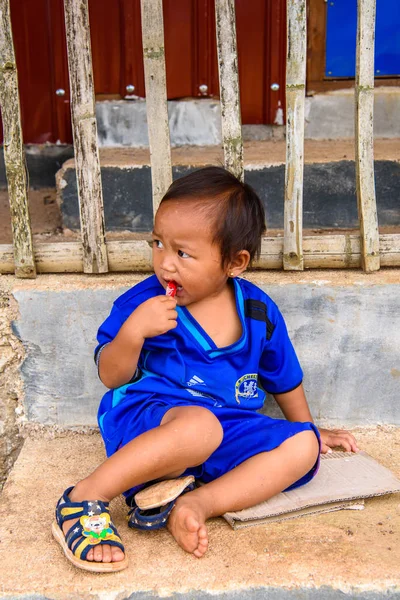 Inle Lake, Myanmar - 30 Ağustos 2016: Sokakta Chelsea forması giyen kimliği belirsiz bir manyacık çocuk. Myanma halkının yüzde 68'i Bamar etnik grubuna mensandı