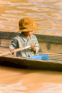 Inle Lake, Myanmar - 30 Ağustos 2016: Ahşap bir teknede tanımlanamayan Birmanyalı küçük çocuk. Myanma halkının yüzde 68'i Bamar etnik grubuna mensandı