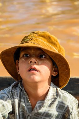 Inle Lake, Myanmar - 30 Ağustos 2016: Ahşap bir teknede şapkalı kimliği belirsiz Birmanyalı çocuk, Inle gölü. Myanma halkının yüzde 68'i Bamar etnik grubuna mensandı