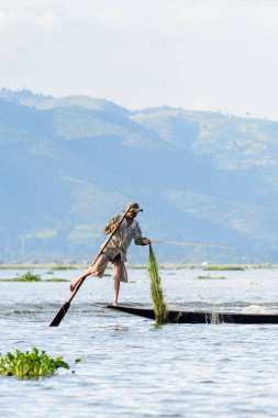 Inle Lake, Myanmar - 30 Ağustos 2016: Özel el yapımı ağı olan bir teknede tanımlanamayan Birmanyalı balıkçı. Bu Myanmar balıkçılık geleneksel yoludur