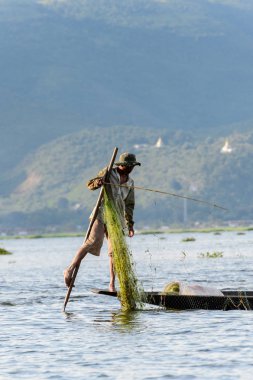 Inle Lake, Myanmar - 30 Ağustos 2016: Özel el yapımı ağı olan bir teknede tanımlanamayan Birmanyalı balıkçı. Bu Myanmar balıkçılık geleneksel yoludur