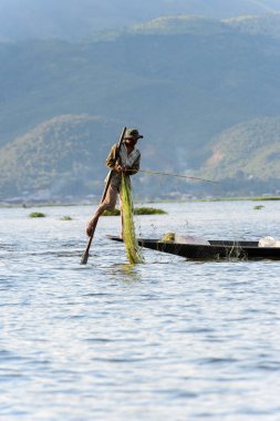 Inle Lake, Myanmar - 30 Ağustos 2016: Özel el yapımı ağı olan bir teknede tanımlanamayan Birmanyalı balıkçı. Bu Myanmar balıkçılık geleneksel yoludur