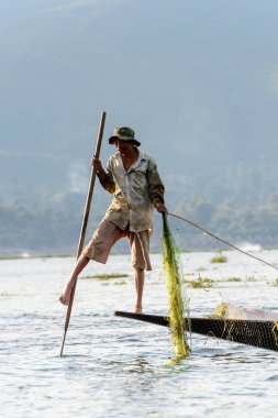 Inle Lake, Myanmar - 30 Ağustos 2016: Özel el yapımı ağı olan bir teknede tanımlanamayan Birmanyalı balıkçı. Bu Myanmar balıkçılık geleneksel yoludur