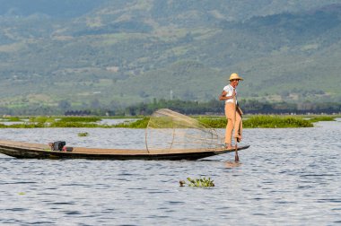 Inle Lake, Myanmar - 30 Ağustos 2016: Özel el yapımı ağı olan bir teknede tanımlanamayan Birmanyalı balıkçı. Bu Myanmar balıkçılık geleneksel yoludur