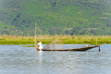 Inle Lake, Myanmar - 30 Ağustos 2016: Özel el yapımı ağı olan bir teknede tanımlanamayan Birmanyalı balıkçı. Bu Myanmar balıkçılık geleneksel yoludur