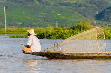 Inle Lake, Myanmar - 30 Ağustos 2016: Özel el yapımı ağı olan bir teknede tanımlanamayan Birmanyalı balıkçı. Bu Myanmar balıkçılık geleneksel yoludur