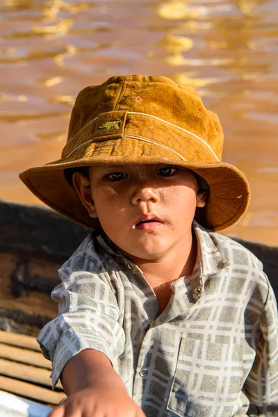 Inle Lake, Myanmar - 30 Ağustos 2016: Ahşap bir teknede şapkalı kimliği belirsiz Birmanyalı çocuk, Inle gölü. Myanma halkının yüzde 68'i Bamar etnik grubuna mensandı
