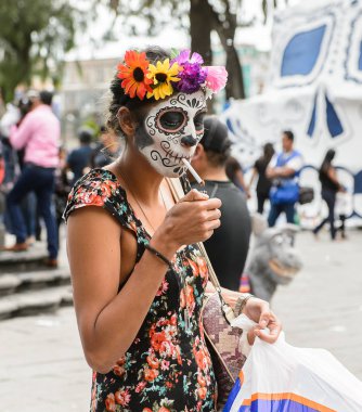 Puebla, Meksika - 30 Ekim 2016: Kimliği belirsiz kız Ölüler Günü (Dia de los Muertos), ulusal Meksika tatili, Unesco İnsanlığın Somut Olmayan Kültürel Mirası için giyinmiş bir sigara içiyor