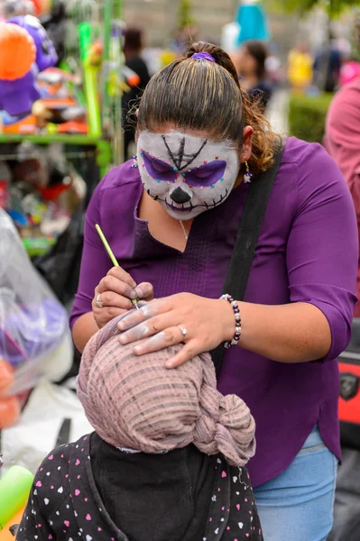Puebla, Meksika - 30 Ekim 2016: Kimliği belirsiz kadın Ölüler Günü (Dia de los Muertos), ulusal Meksika tatili, Unesco İnsanlığın Somut Olmayan Kültürel Mirası için makyaj yapıyor