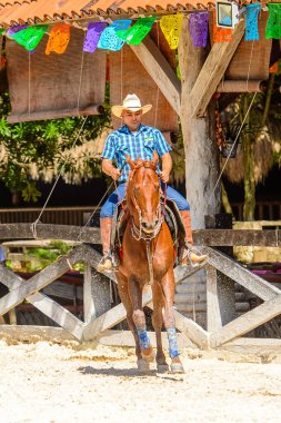 Xcaret, Meksika - 7 Kasım 2016: Kimliği belirsiz kovboy, Meksika'nın Xcaret parkında ata biniyor