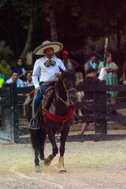 Xcaret, Meksika - 7 Kasım 2016: Kimliği belirsiz Meksikalı kovboy ata biniyor ve Xcaret parkında numaralar gösteriyor, Mexioc