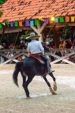 Xcaret, Meksika - 7 Kasım 2016: Kimliği belirsiz Meksikalı kovboy ata biniyor ve Xcaret parkında numaralar gösteriyor, Mexioc