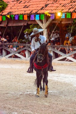 Xcaret, Meksika - 7 Kasım 2016: Kimliği belirsiz Meksikalı kovboy ata biniyor ve Xcaret parkında numaralar gösteriyor, Mexioc