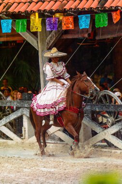 Xcaret, Meksika - 7 Kasım 2016: Ulusal elbiseli tanımlanamayan Meksikalı kovboy kız, Mexioc, Xcaret parkında bir ata biniyor