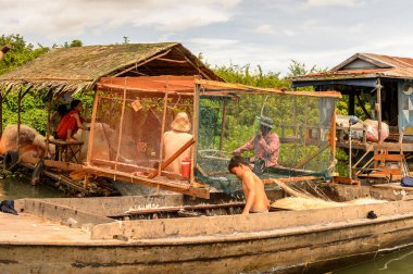 Lake Tonle Sap, Combodia - 28 Eylül 2014: Kimliği belirsiz kişiler, Güneydoğu Asya'nın en büyük tatlı su gölü olan 1997'den beri Unesco biyosferi olan Tonle Sap Gölü'nde balık ağı yapıyorlar.