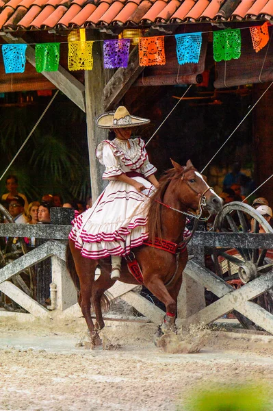 Xcaret, Meksika - 7 Kasım 2016: Ulusal elbiseli tanımlanamayan Meksikalı kovboy kız, Mexioc, Xcaret parkında bir ata biniyor