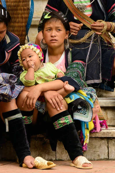 Sapa, Vietnam - 20 Eylül 2014: Geleneksel kostümlü tanımlanamayan Hmong kadın küçük bebeğini taşıyor. Hmong halkı Sapa'da yaşayan bir azınlık etnik grubudur.