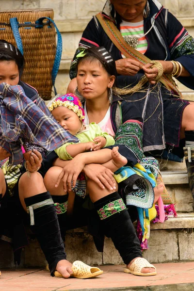 Sapa, Vietnam - 20 Eylül 2014: Geleneksel kostümlü tanımlanamayan Hmong kadın küçük bebeğini taşıyor. Hmong halkı Sapa'da yaşayan bir azınlık etnik grubudur.