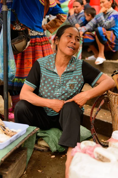 Bac Ha, Vietnam - 21 Eylül 2014: Kimliği belirsiz kadın, güzel renkli azınlık kostümleri giyen insanlarla büyük bir Pazar pazarı olan Bac Ha Market'te çalışıyor