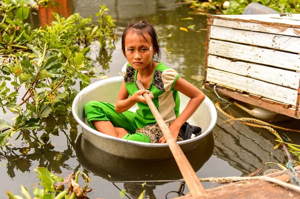 Lake Tonle Sap, Combodia - 28 Eylül 2014: Tanımlanamayan Vietnamlı kız, Güneydoğu Asya'nın en büyük tatlı su gölü olan Tonle Sap Gölü'nde leğen kemiğinde bir yılanla yelken açar.
